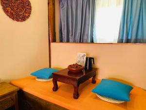 una mesa con 2 almohadas azules y un espejo en Juxian Boutique Homestay en Lijiang