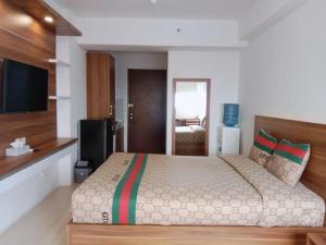 1 dormitorio con 1 cama grande y TV en Sansan Room - Apartemen Gunung Putri Square, en Parungdengdek