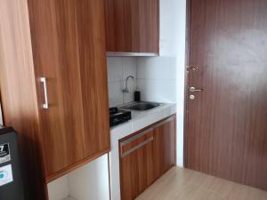 a small kitchen with a sink and a stove at Sansan Room - Apartemen Gunung Putri Square in Parungdengdek