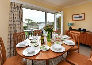 a dining room with a table and chairs and a window at 10 Llwyn Onn Beach Hut in Abersoch