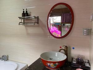 a bathroom with a large bowl sink and a mirror at Juxian Boutique Homestay in Lijiang