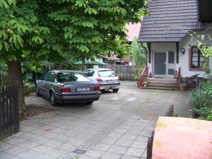 deux voitures garées devant une maison dans l'établissement Pension Zur Sonne Wittenweier, à Schwanau