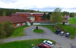 un bâtiment avec des voitures garées dans un parking dans l'établissement Hotell Vindelngallerian, à Vindeln