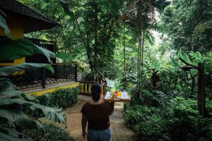 una mujer sosteniendo una mesa en un bosque en Peach Hill Resort - SHA Extra Plus en Kata