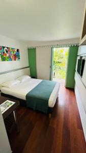 a bedroom with a large bed and a window at Hotel Exsel Alamanda in Saint-Gilles les Bains