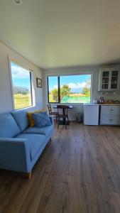 a living room with a blue couch and a table at Beach Break Cabin 2 in Pohara