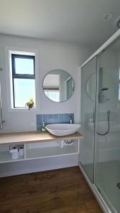 a bathroom with a sink and a mirror at Beach Break Cabin 2 in Pohara