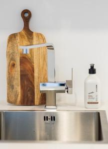 a kitchen counter with a sink and a cutting board at A touch of Luxury in Chch CBD in Christchurch