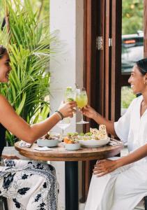 two women sitting at a table with drinks at Good Mantra Studio in Canggu