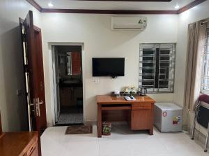 an office with a desk and a television in a room at Khách Sạn Hồng Hảo in Lao Cai