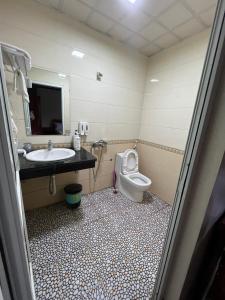 La salle de bains est pourvue d'un lavabo et de toilettes. dans l'établissement Khách Sạn Hồng Hảo, à Lào Cai