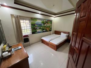 una camera da letto con un letto e un dipinto sul muro di Khách Sạn Hồng Hảo a Lao Cai