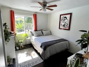 a bedroom with a bed with a fan and a window at Desert Oasis- *Pool and Hot Tub* in Phoenix