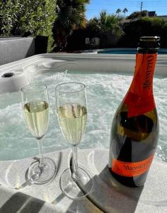 two glasses of white wine next to a bottle of champagne at Desert Oasis- *Pool and Hot Tub* in Phoenix
