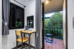 a room with a desk and a balcony at D-2 Home in Chanthaburi