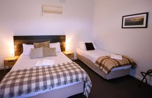 een slaapkamer met 2 bedden en 2 lampen bij Meeniyan Motel in Meeniyan +25 foto's