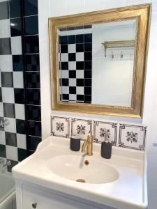 lavabo blanco en el baño con espejo en Jindabyne - Kia Ora Cabin Farmstay en Moonbah