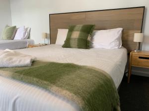 1 dormitorio con 2 camas y almohadas verdes y blancas en Meeniyan Motel, en Meeniyan
