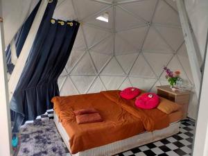 Un dormitorio con una cama con almohadas rojas. en Monteadeo Camping, en Mon Jam