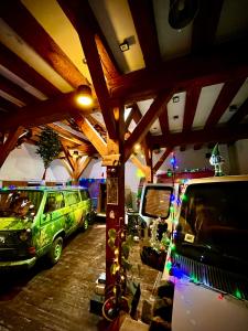 Dos furgonetas verdes estacionadas en un garaje con luces de Navidad en Urban Van Glamping Riga en Riga