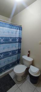 a bathroom with a toilet and a shower curtain at Confortable habitación in Colonia Alamitos