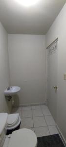 - une salle de bains blanche avec 2 toilettes et un lavabo dans l'établissement Confortable habitación, à Colonia Alamitos