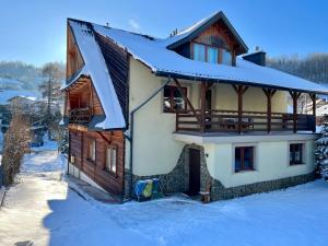 ein Haus mit einem großen Buchstaben k im Schnee in der Unterkunft Willa Słotwinka in Krynica-Zdrój