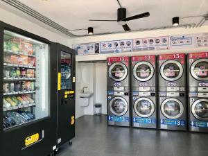 uma fila de máquinas de lavar roupa numa loja em Luka House em Lam Luk Ka