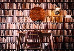 a table and a chair in front of a wall of books at The Shore by Pinstay in Kota Kinabalu