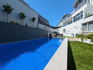 a swimming pool in the backyard of a house at The Coastal Getaway in Mount Maunganui