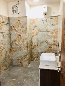 a bathroom with a sink and a stone wall at The highclass hotel in Bathinda