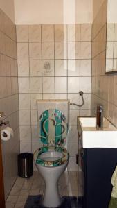 een badkamer met een toilet en een groene stoel bij Ferienwohnung Margit in Förolach
