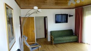 een woonkamer met een groene bank en een tv bij Ferienwohnung Margit in Förolach