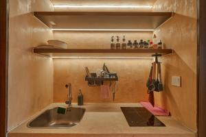 a kitchen with a sink and a shelf above it at Bstudio in APEC Mandala Mũi Né in Phan Thiet
