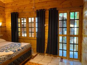 a bedroom with a bed and two windows at Chill Out Jasmine Restaurant Bar Rooms in Palolem