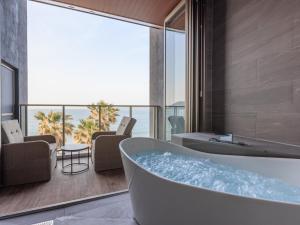 a bathroom with a tub and a view of the ocean at Alba HOTEL & Glamping in Nishinoura +109 photos