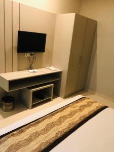 a room with a tv and a desk with a computer at The highland hotel in Bathinda