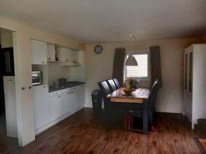 eine Küche mit einem Tisch und Stühlen sowie ein Esszimmer in der Unterkunft Lodge Damian op de Veluwe in Voorthuizen