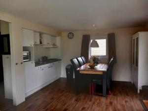 a kitchen with a table and chairs and a dining room at Lodge Damian op de Veluwe in Voorthuizen