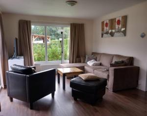 a living room with a couch and a table at Lodge Damian op de Veluwe in Voorthuizen