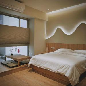 1 dormitorio con cama grande y cabecero de madera en 沐正農場 嘉義包棟民宿, en Zhongpu