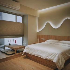 a bedroom with a large bed and a wooden headboard at 沐正農場 木一館 嘉義包棟民宿 in Zhongpu +31 photos