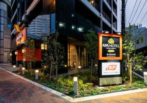 a sign on a sidewalk in front of a building at APA Hotel Osaka Umeda in Osaka