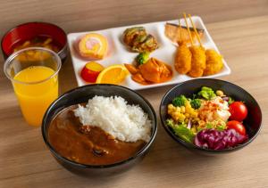 una mesa con dos tazones de comida y un plato de comida en APA Hotel Osaka Umeda, en Osaka