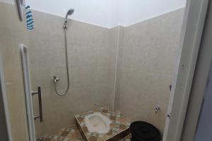 a shower stall with a toilet in a bathroom at SPOT ON 93350 Alnasya Syariah in Palembang