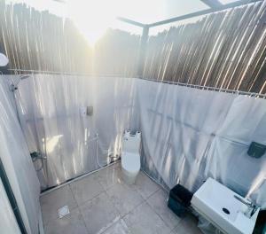 a bathroom with a toilet and a shower and a sink at Al Salam Desert Camp Bidiya in Bidiyah