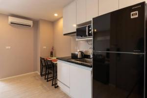 a kitchen with a black refrigerator and a counter top at Modern Condo in Nimman (F806) by Pimolplace in Chiang Mai