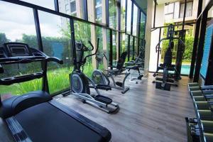 a gym with several exercise bikes in a room with windows at Modern Condo in Nimman (F806) by Pimolplace in Chiang Mai