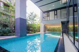 a swimming pool in front of a house at Modern Condo in Nimman (F806) by Pimolplace in Chiang Mai
