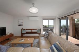 uma sala de estar com um sofá e uma mesa em Bayview Bliss em Surf Beach